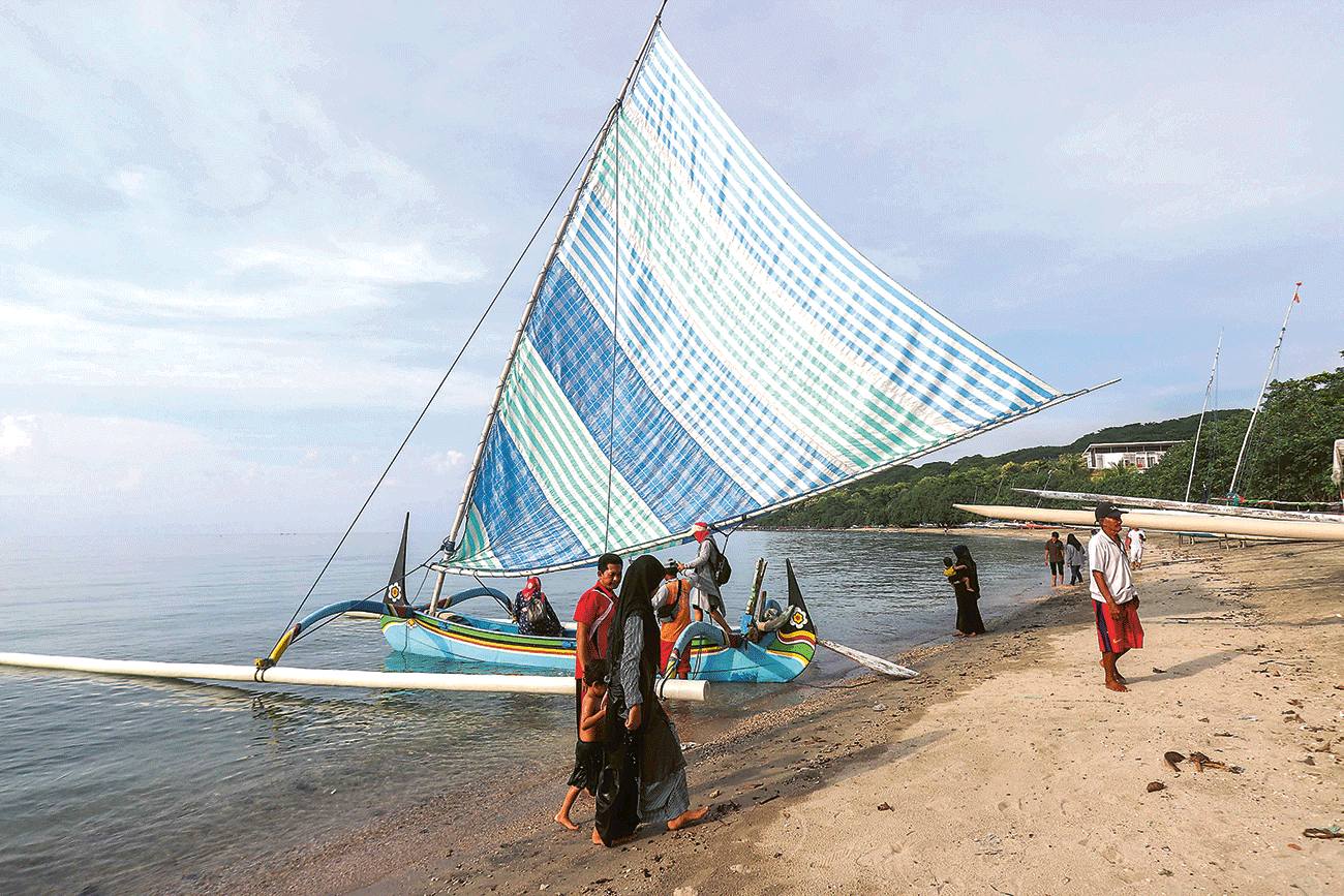 DI TEPI JALAN RAYA: Sejumlah pengunjung menikmati suasana senja di Pantai Pasir Putih, Situbondo (6/3). - Image
