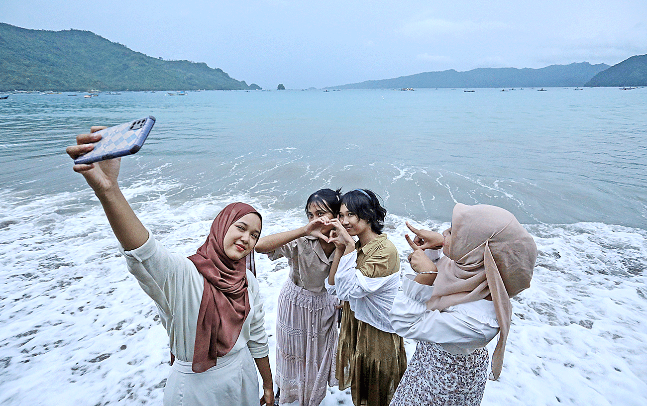PILIHAN TEMPAT BERISTIRAHAT: Sejumlah pengunjung berfoto di Pantai Simbaronce, Trenggalek (8/3). - Image