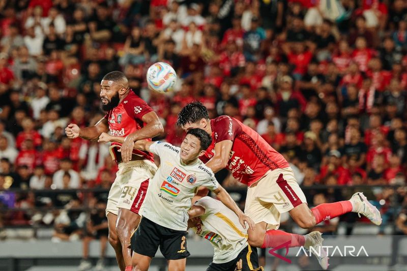 Dua pemain Bali United Jefferson Assis (kiri) dan Elias Dolah (kanan) berebut bola dengan pemain Persija Jakarta Ilham Rio Fahmi (tengah). - Image