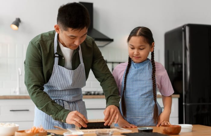 Ilustrasi seorang ayah sedang mengajari anak tentang cara membuat sushi dengan penuh cinta dan kasih sayang (freepik) - Image