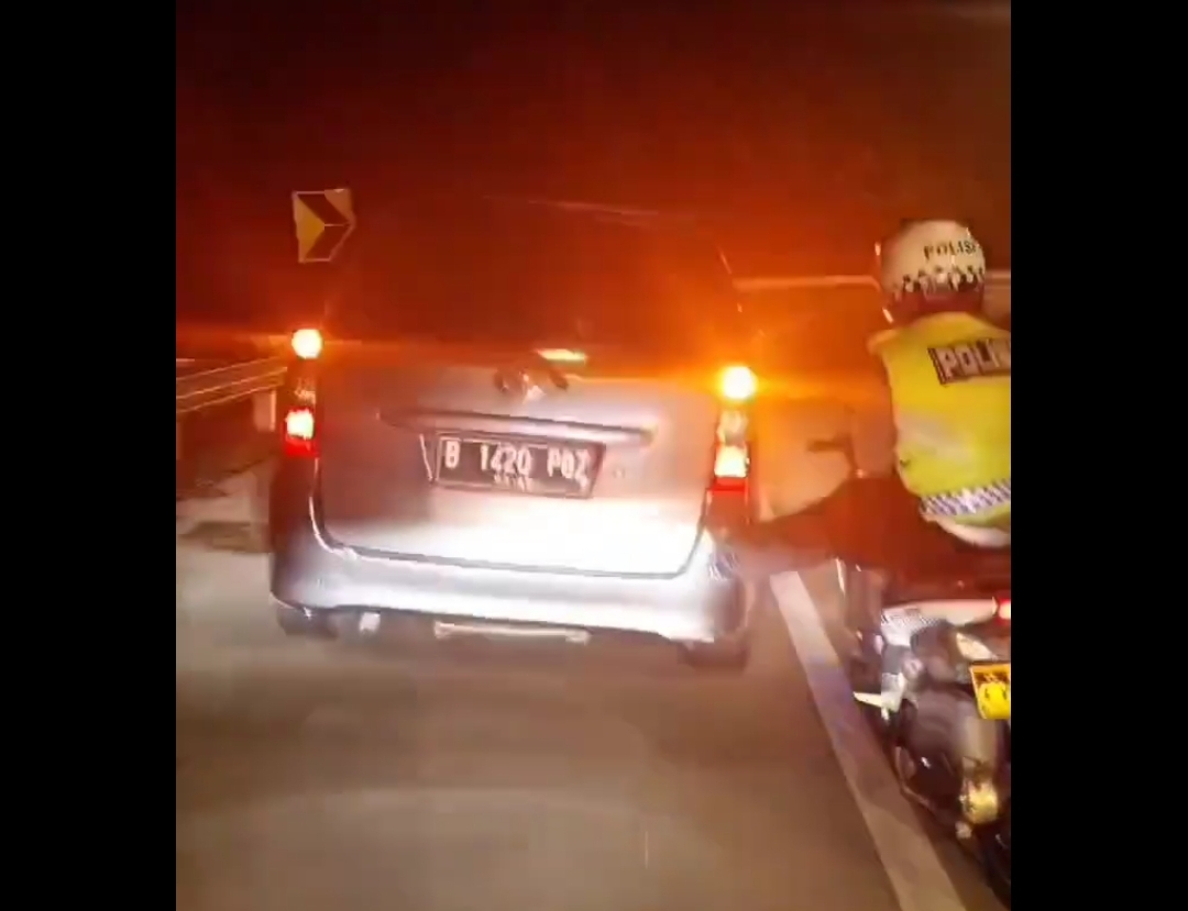 Viral di media sosial seorang polisi melakukan stut atau mendorong mobil mogok dengan kaki di ruas jalan tol Cipali hingga ke arah gerbang tol Subang. - Image