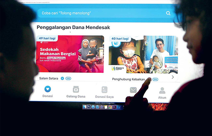 SELEKTIF: Dua pengguna internet mempertimbangkan pilihan donasi, Jumat (12/4). Laman Kitabisa.com menampilkan banyak opsi penggalangan dana oleh komunitas maupun perorangan. - Image