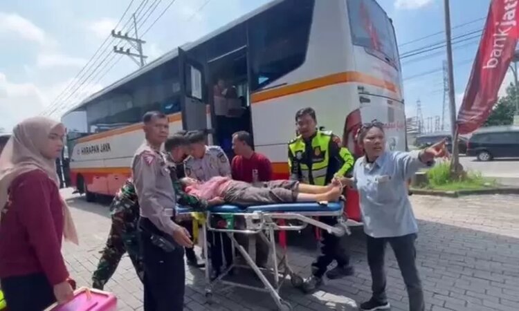 Petugas mengevakuasi penumpang bus PO Harapan Jaya yang pingsan, di Rest Area Gunung Gedangan, Kecamatan Magersari, Kota Mojokerto. (foto: Moch. Chariris) - Image