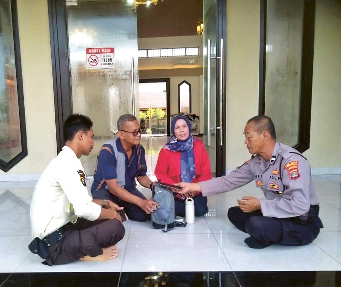 TANGGUNG JAWAB: Aiptu Supriyanto (kanan) mengembalikan tas milik Sukisno (dua dari kiri) di masjid rest area Km 116 jalan tol Trans Sumatera (14/4). - Image