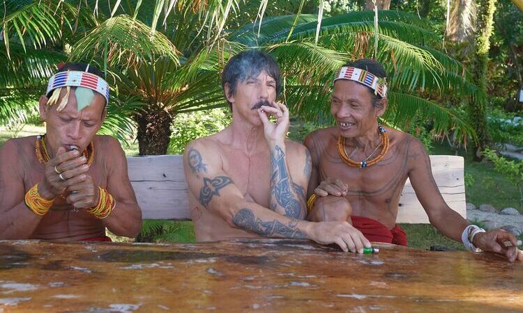 Vokalis RHCP, Anthony Kiedis, sedang menikmati tembakau bersama dua warga lokal Pulau Mentawai. (Sumber foto: Instagram @chilipeppers) - Image