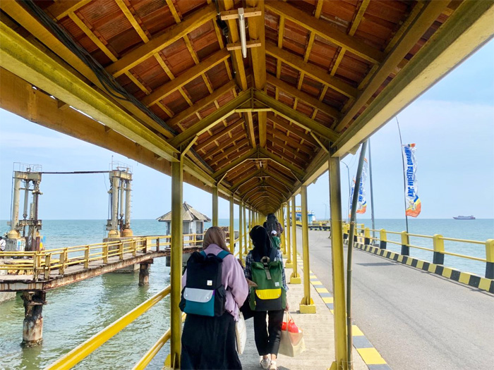 Suasana dermaga penyeberangan lintas pulau. Sejumlah penumpang melintas menuju kapal Ferry antar pulau. - Image