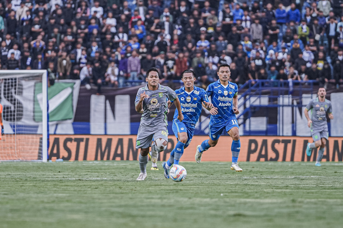 Pemain Persebaya, Toni Firmansyah melakukan serangan sesuai melewati penjagaan pemain Persib Bandung./laman resmi Persebaya - Image