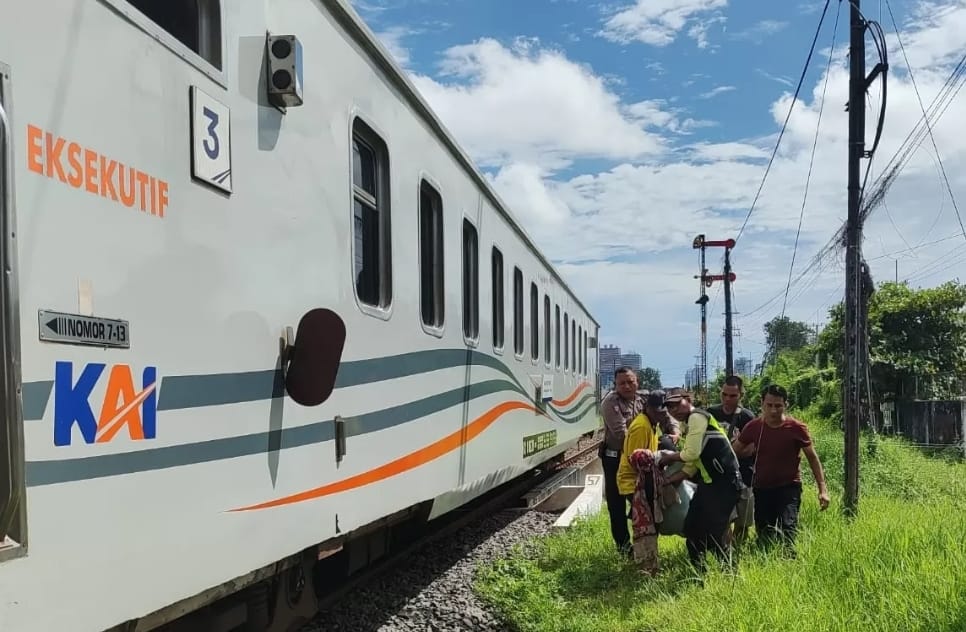 Polisi bersama warga mengevakuasi korban tertabrak KA di Waru, Jumat (26/4) - Image