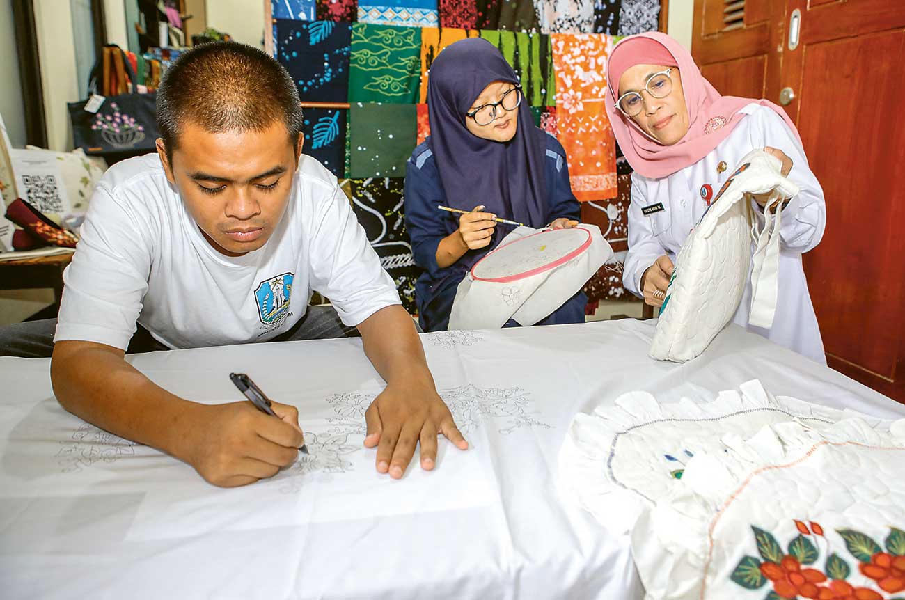 WADAH BEREKSPRESI: Kadinsos Jawa Timur Restu Novi Widiani (kanan) berinteraksi dengan penyandang disabilitas Aprilianto Wibowo (kiri) serta Erlina di Gadisku Pemprov Jatim, Surabaya (24/4). - Image