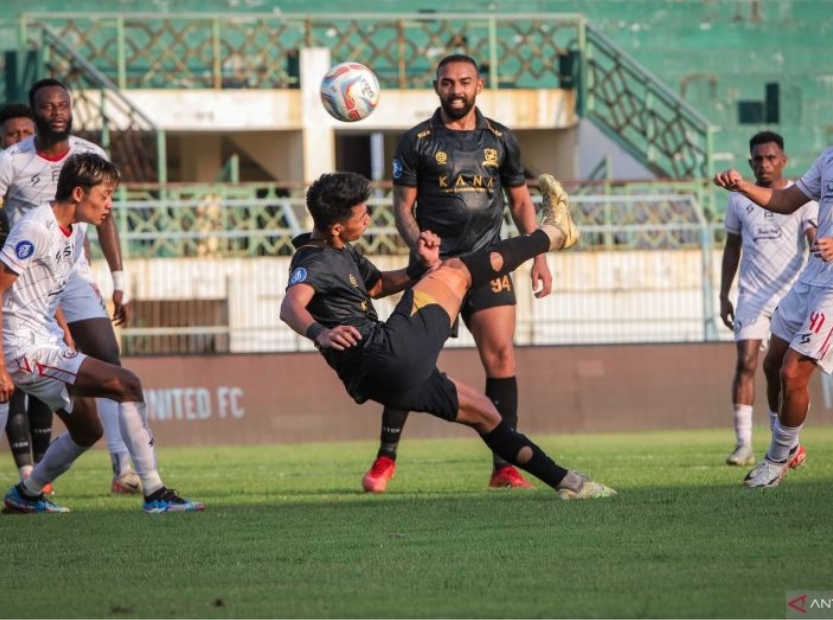 Pesepak bola Madura United Malik Risaldi (tengah) melakukan tendangan salto ke arah gawang Arema FC - Image