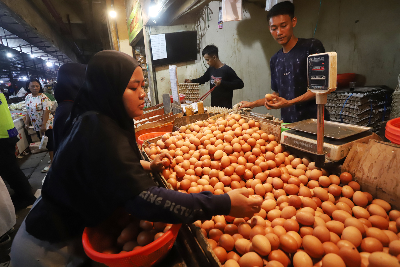 Pedagang saat merapihkan telur ayam di toko miliknya di Pasar Kebayoran Lama, Jakarta. - Image
