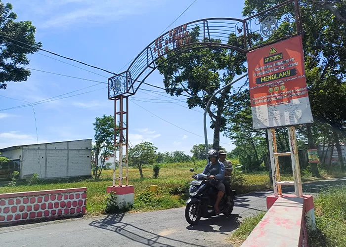 Warga RW 1 Kelurahan Gayam memasang banner penolakan hasil penaksiran harga tanah terdampak Tol Kediri-Tulungagung yang dinilai rendah. (Foto: Ayu Isma/JPRK) - Image
