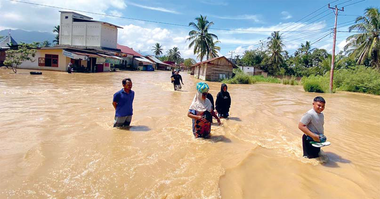 MENEMBUS BANJIR: Sejumlah warga berjalan di kawasan permukiman terdampak banjir di Nagari Taram, Kecamatan Harau, Kabupaten Limapuluph Kota, Senin (13/5). - Image