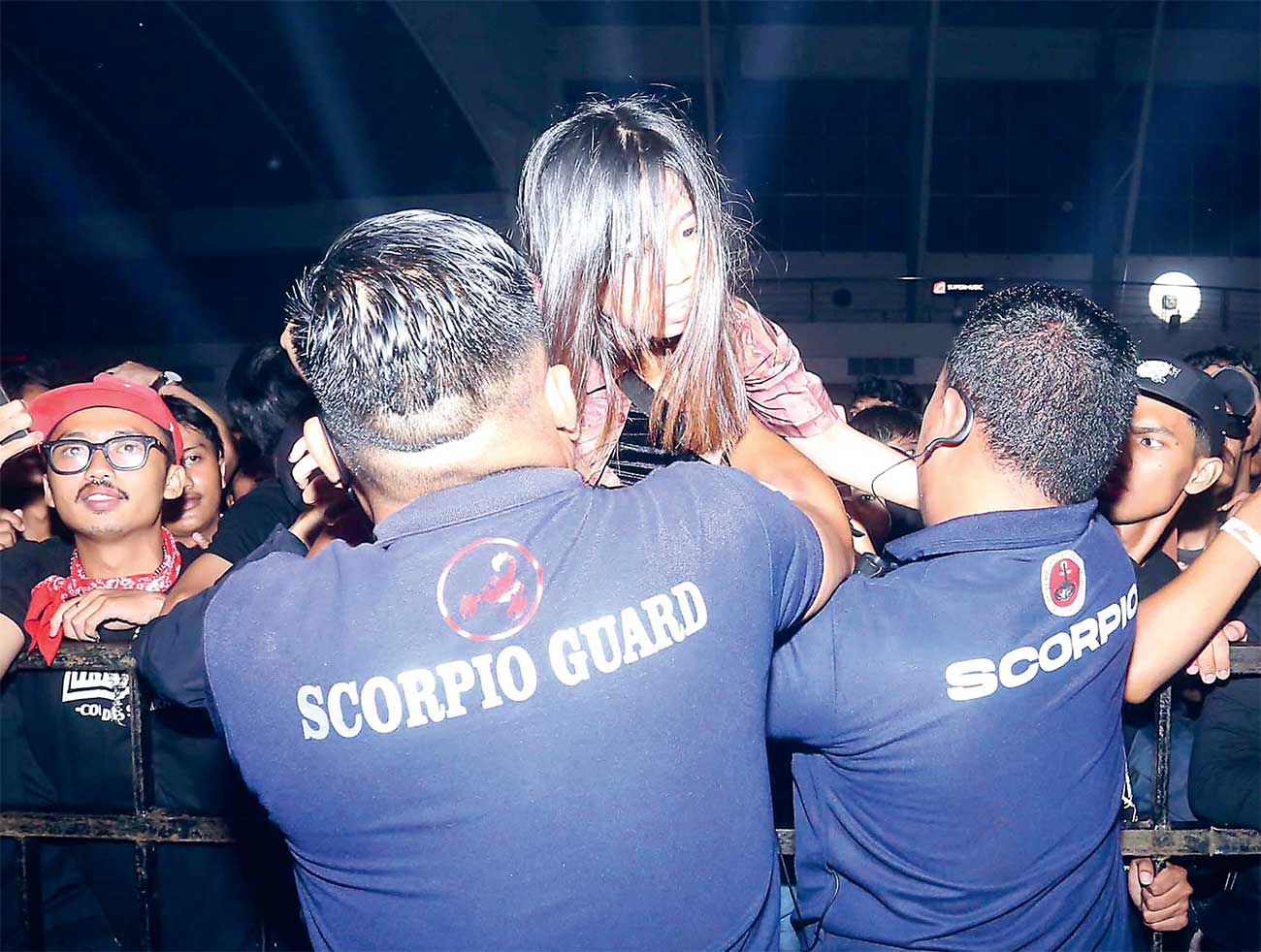 SIGAP: Dua petugas keamanan membantu penonton perempuan di depan panggung Loud Carnival 4 di Jatim Expo Surabaya pada 9 Maret lalu. - Image