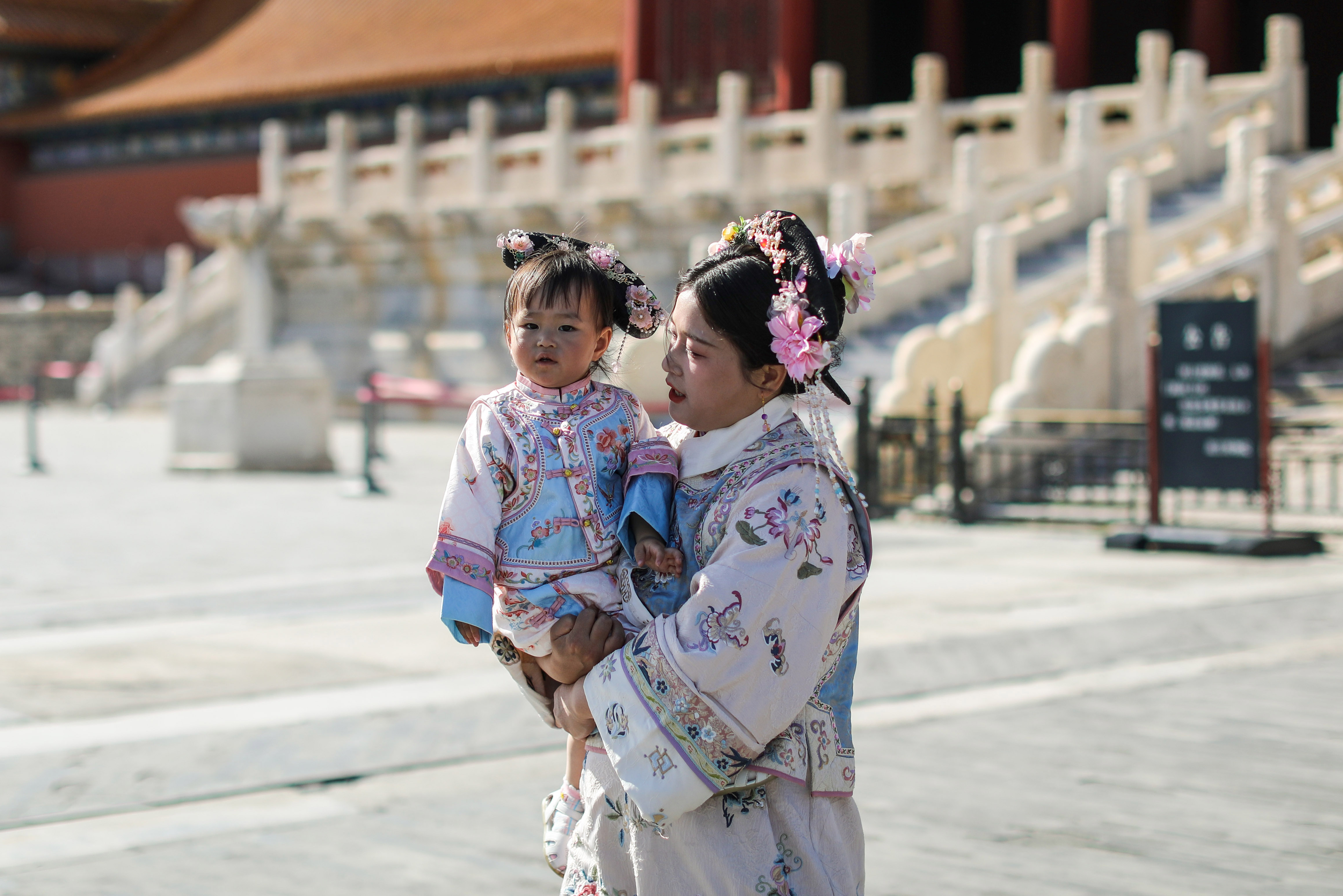 Seorang Ibu dan anaknya mengenakan pakaian tradisional Tiongkok bercengkrama di kawasan Forbidden City, Beijing, Rabu (15/5/2024). - Image
