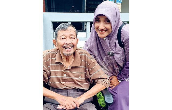 OPTIMISTIS: Retno bersama ayah mertuanya yang mengidap demensia. - Image