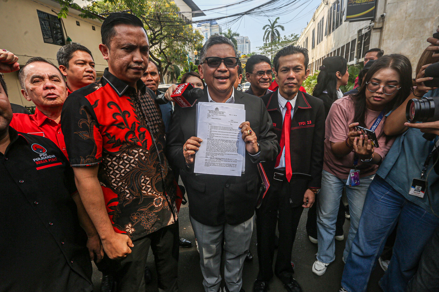Sekjen PDI Perjuangan Hasto Kristiyanto (tengah) bersama Tim Hukum PDI Perjuangan menunjukkan berkas undangan pemeriksaan setibanya di gedung Ditreskrimum Polda Metro Jaya, Jakarta, Selasa (4/6/2024). 