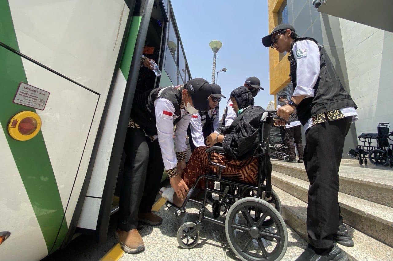 Petugas PPIH Arab Saudi membantu seorang jemaah yang dipindahkan dari hotelnya ke hotel transit di Makkah untuk mengikuti safari wukuf - Image