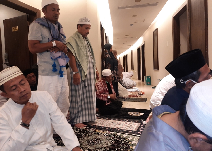 Jamaah Indonesia melaksanakan shalat berjamaah di lorong kamar selain di musala hotel setelah operasional bus shalawat dihentikan sementara menjelang Wuquf di Arofah. - Image