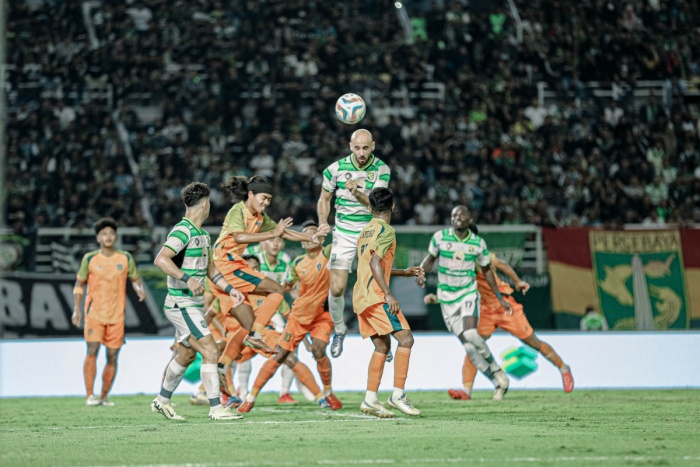Muhammad Rashid (tengah) menyundul bola yang membuat Persebaya Surabaya memecahkan kebuntuan saat menghadapi Persibo Bojonegoro dalam Anniversary Game di Stadion GBT, Sabtu (29/6) malam. (Persebaya) - Image