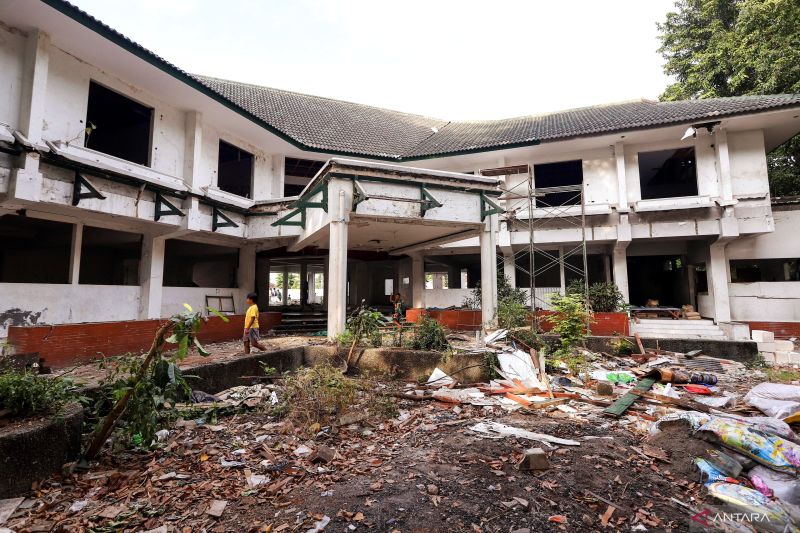 Sejumlah anak melintas di depan bangunan Wisma Karanggayam, Surabaya, Minggu (30/6/2024). - Image