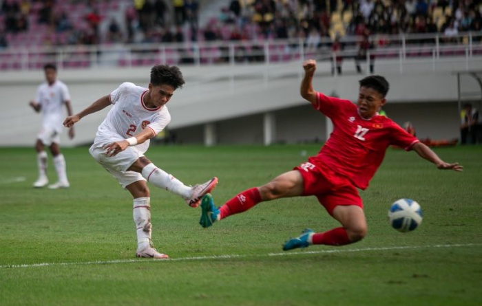 Dafa Zaidan El Fikri (kiri) berebut bola dengan pemain Vietnam Nguyen Thai Hieu pada pertandingan perebutan juara ketiga Piala AFF U-16 di Stadion Manahan. (ANTARA/Muhammad Ayudha) - Image
