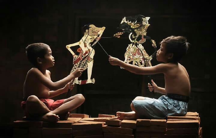 Ilustrasi dua orang bocah sedang bermain wayang kulit. - Image