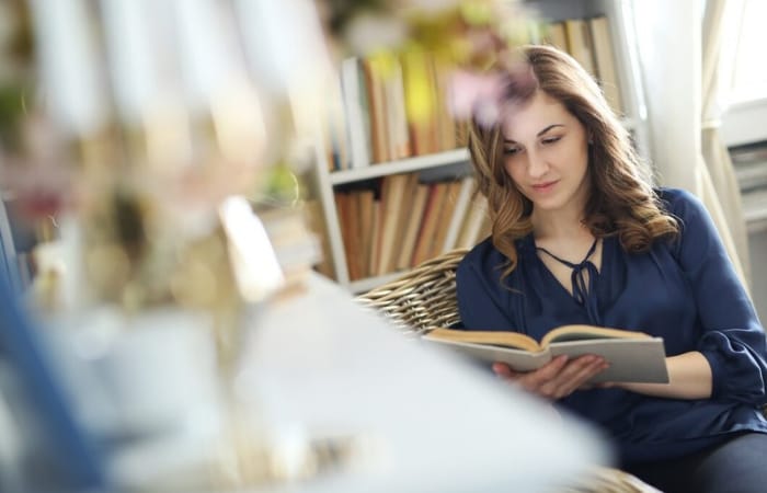 Ilustrasi seorang perempuan memulai aktivitas paginya dengan membaca sebuah buku. - Image