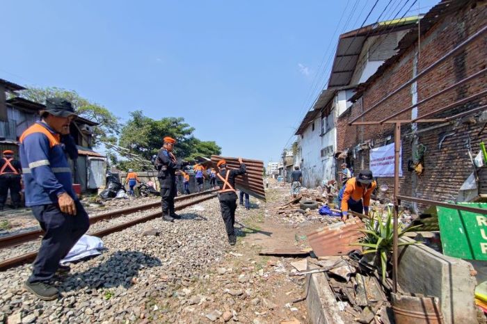 Petugas KAI Daop 8 bongkar bangunan liar lakukan sterilisasi jalur KA lintas Stasiun Malang-Stasiun Blimbing, Kamis (25/7). (KAI Daop 8 Surabaya/Antara) - Image