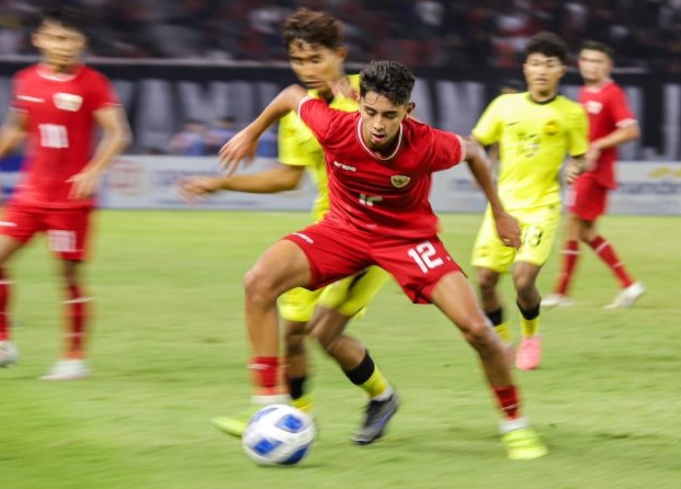 Pemain Indonesia U-19 Welber Jardim berebut bola dengan pemain Malaysia saat pertandingan semifinal ASEAN U-19 Boys Championship di Stadion GBT Surabaya, Sabtu (27/7/2024). (ANTARA FOTO/Rizal Hanafi) - Image