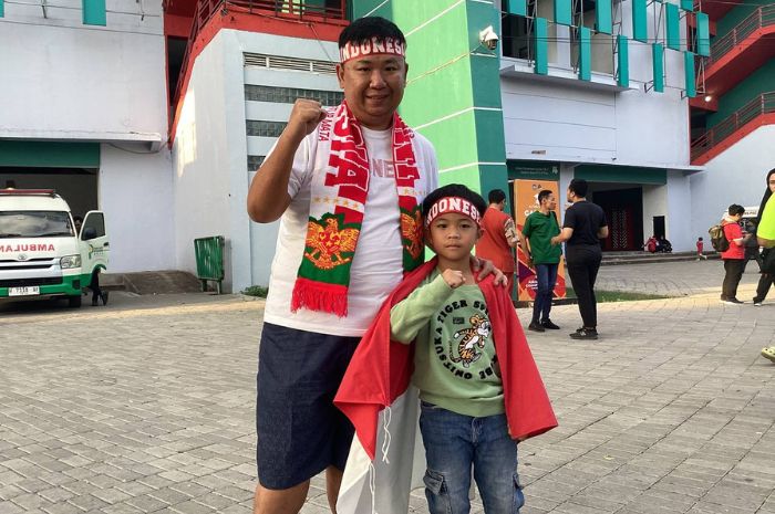 Momen suporter Timnas Indonesia U-19 Frenky dan anaknya, Javier, di depan Stadion Gelora Bung Tomo Surabaya. (Moch. Rizky Pratama Putra/JawaPos.com) - Image