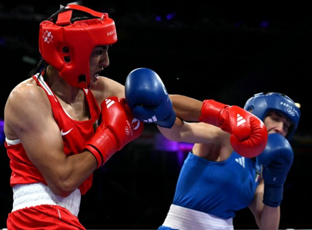 Petinju Aljazair Imane Khelif (merah) saat berhadapan dengan wakil Italia Angela Carini pada babak 16 besar tinju putri 66 kg di Olimpiade Paris 2024, Kamis (1/8/2024). (ANTARA/AFP/M RASFAN) - Image
