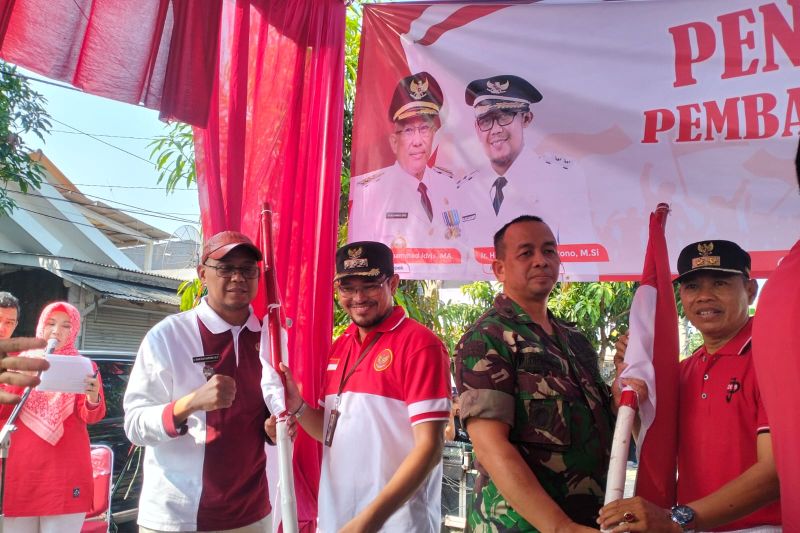 Wakil Wali Kota Depok Imam Budi Hartono (kiri) mencanangkan gerakan pembagian Bendera Merah Putih, Sabtu (3/8/2024). (Feru Lantara/ANTARA) - Image
