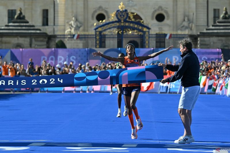 Pelari Belanda, Sifan Hassan saat melintasi garis finis pada nomor maraton putri Olimpide Paris 2024 yang berlangsung di Invalides, Paris, Minggu (11/08/2024). (ANTARA/AFP/ANDREJ ISAKOVIC) - Image
