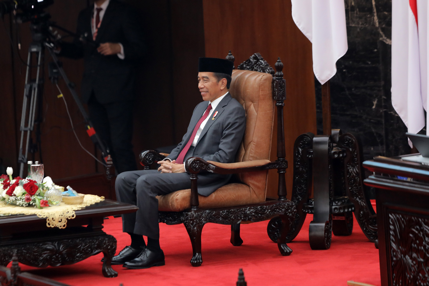 Presiden Joko Widodo duduk di kursi sebelum menyampaikan pidato keterangan pemerintah atas RUU tentang APBN Tahun Anggaran 2025. (Sopian/ Pool Foto Parlemen) - Image