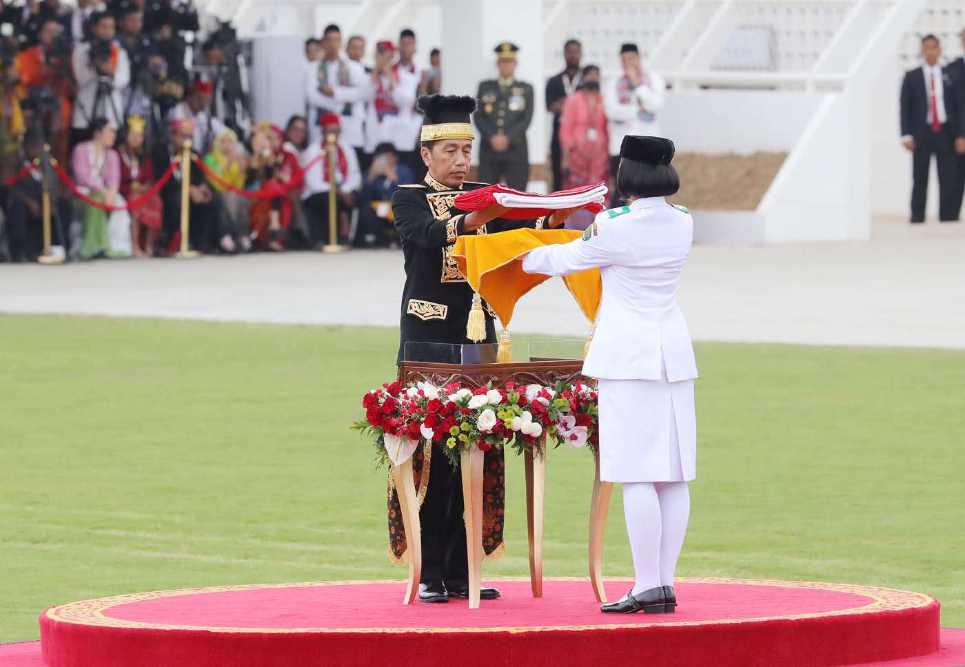 Presiden Joko Widodo (kiri) menyerahkan duplikat Bendera Pusaka kepada anggota Paskibraka 2024 asal Kalimantan Timur Livenia Evelyn Kurniawan (kanan) untuk dikibarkan dalam upacara Peringatan Detik-detik Proklamasi Kemerdekaan Republik Indonesia (RI) di l - Image