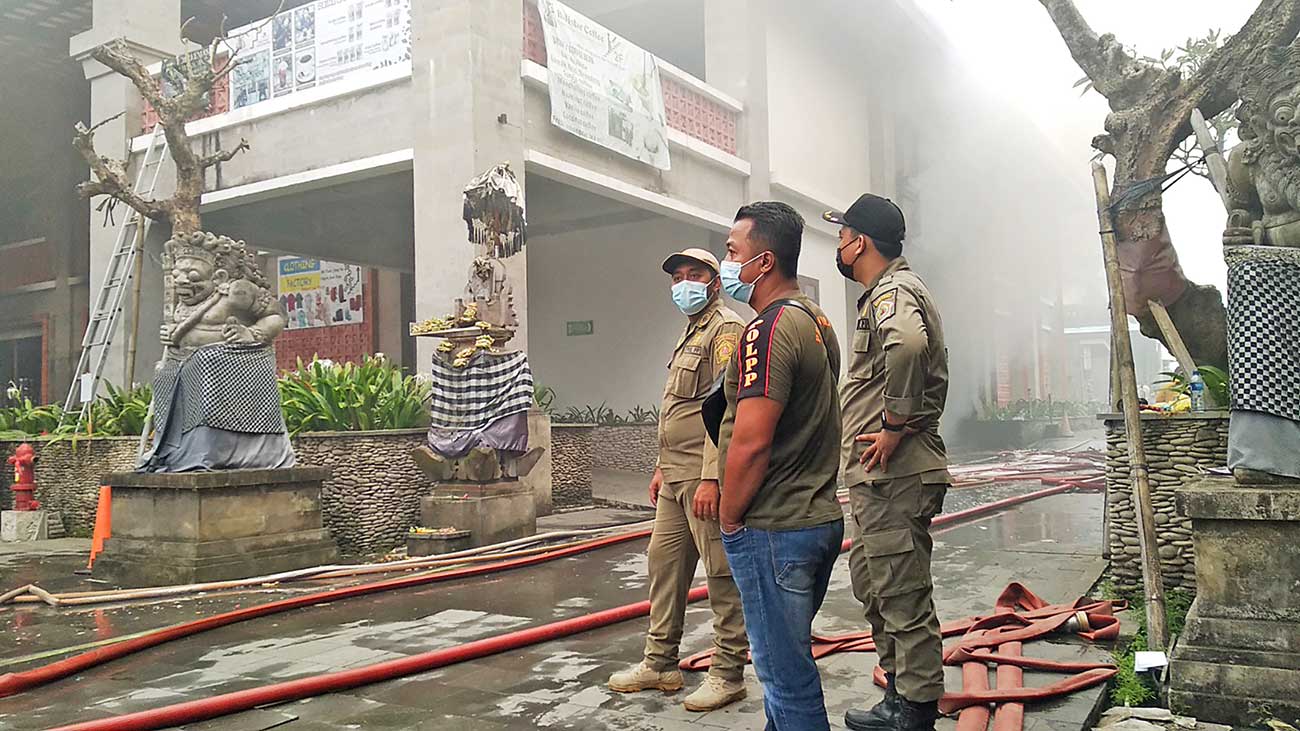 DALAM PENYELIDIKAN: Sejumlah petugas berjaga di Pasar Ubud kemarin (18/8) setelah sehari sebelumnya terbakar. (IDA BAGUS INDRA PRASETIA/JAWA POS RADAR BALI) - Image