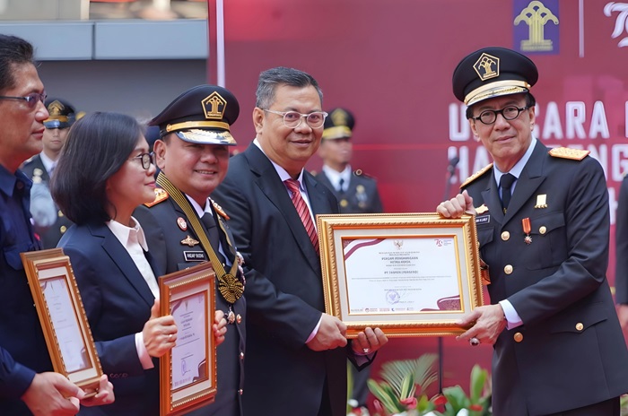 Menkumham Yasonna H. Laoly menyerahkan penghargaan kepada Direktur Operasional Taspen Ariyandi, di Lapangan Upacara Kemenkumham, Jakarta Selatan (19/8). (dok. Taspen) - Image