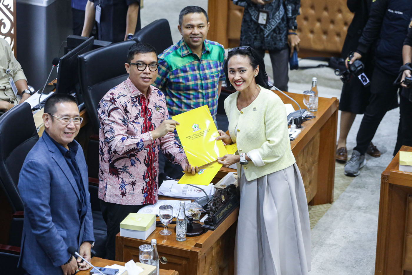 Wakil Ketua Badan Legislasi DPR RI Achmad Baidowi (tengah) menerima berkas pandangan mini Fraksi Partai Golkar dari Anggota Badan Legislasi DPR RI Christina Aryani (kanan) dalam rapat keputusan pembahasan RUU Pilkada DPR RI dengan Badan Legislasi DPR RI d - Image