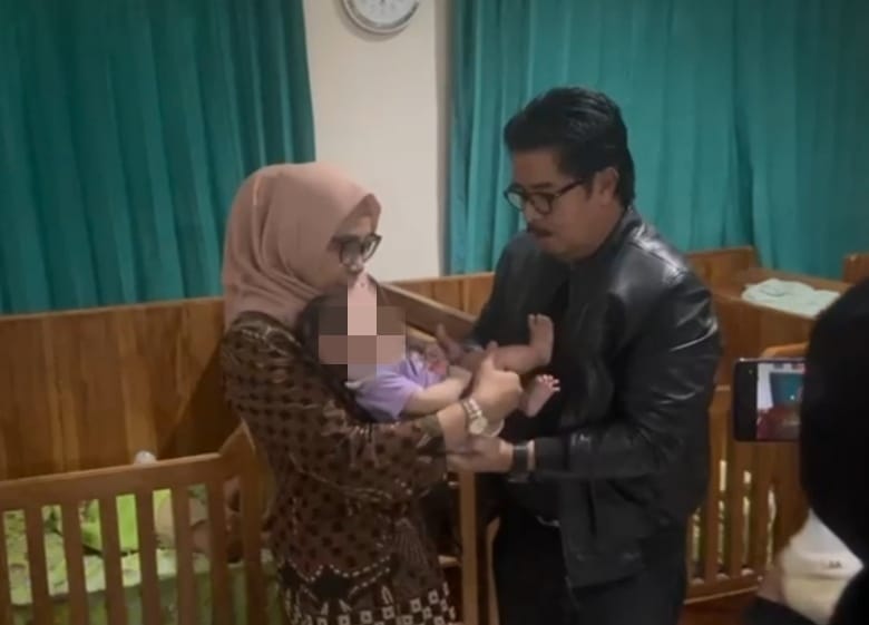 Ketua Muda Tata Usaha Negara Mahkamah Agung, Prof. Dr. H. Yulius memegang bayi Fawwaz Ubaida di Panti Asuhan Bayi Sehat, Bandung. (Mahkamah Agung Peduli) - Image