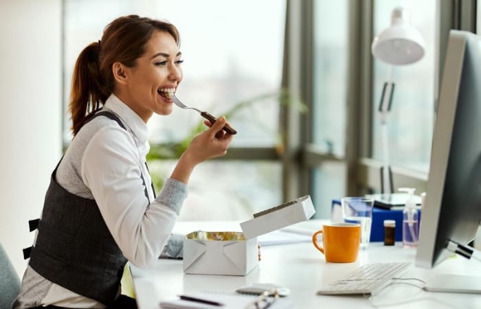 Ilustrasi perempuan yang makan siang sendiri di kantor. (Freepik) - Image