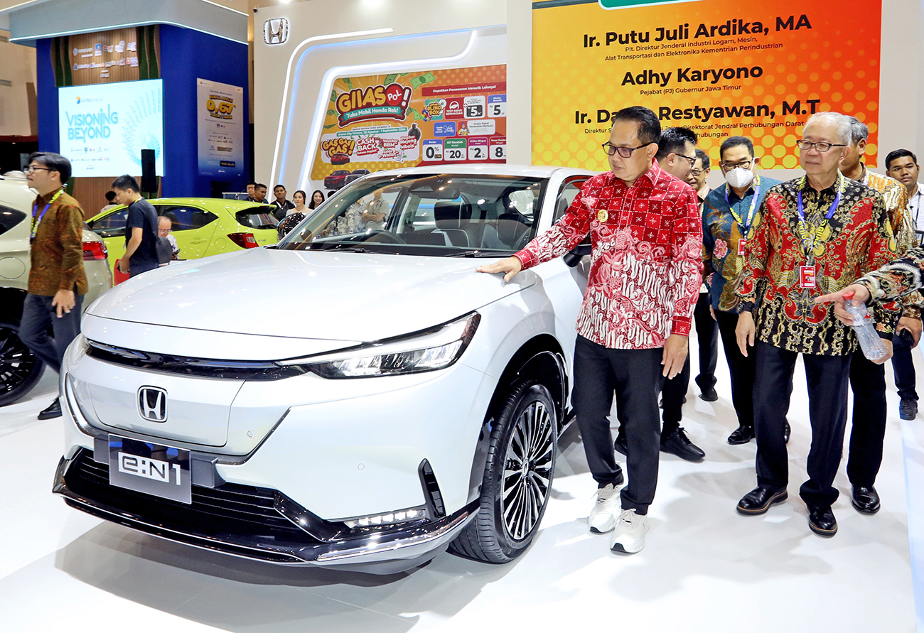 OPTIMISME BARU: Penjabat (Pj) Gubernur Jawa Timur Adhy Karyono (kiri) didampingi Ketua Umum Gaikindo Yohannes Nangoi melihat Honda e:N1 di booth Honda seusai membuka GIIAS 2024 di Surabaya kemarin. - Image