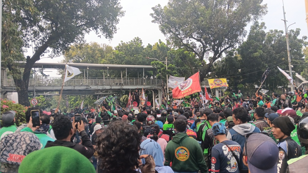 Para driver ojol menggelar aksi demo di sekitar patung kuda atau Arjuna Wijaya, Kamis (29/8), menuntut perbaikan kesejahteraan. (Tazkia Royyan/JawaPos.com) - Image