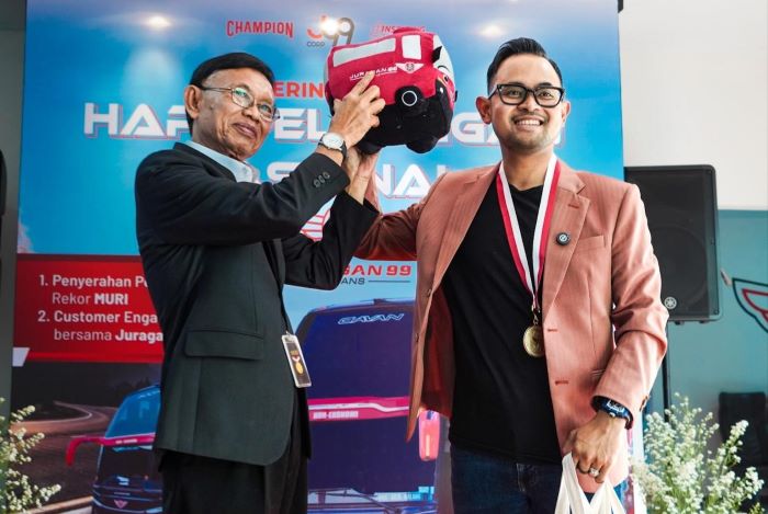 Founder Juragan 99 Trans Gilang Widya Pramana memberikan suvenir pada hari pelanggan nasional. (Istimewa) - Image