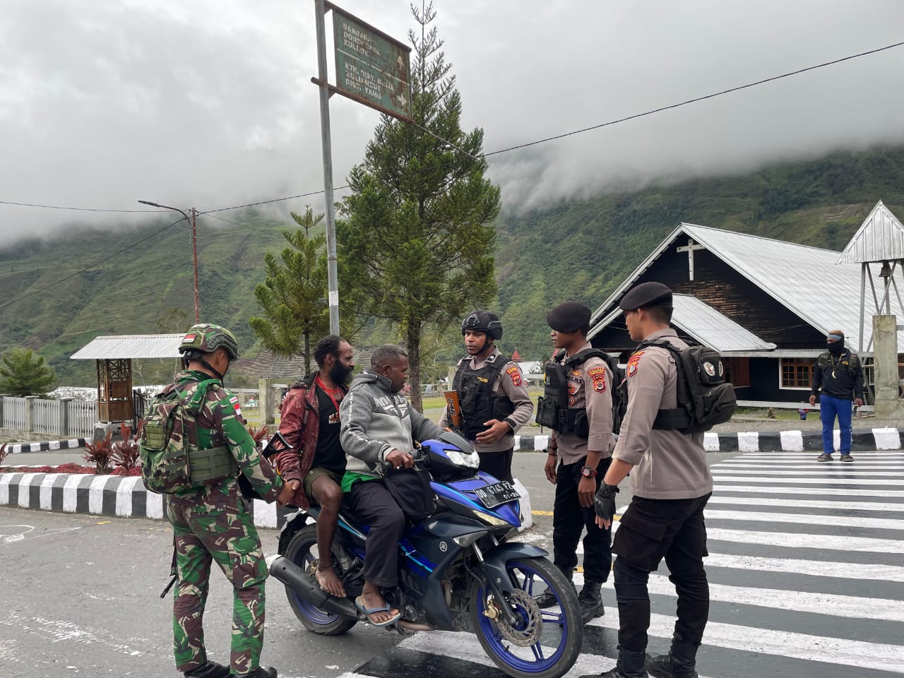 Satgas TNI dan Polri memeriksa kendaraan yang melintas di perbatasan Kabupaten Puncak Jaya, Papua pada Jumat (6/9). (Kodam Cenderawasih) - Image