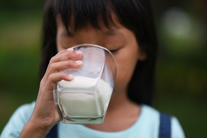 Ilustrasi seorang anak yang sedang meminum susu. - Image