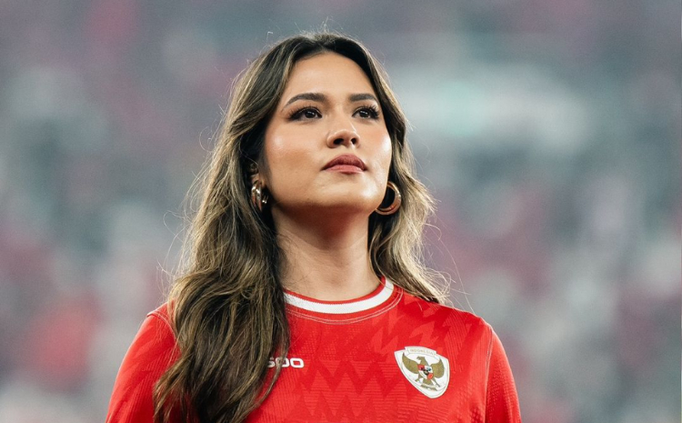 potrait Raisa menggunakan jersey timnas merah dengan rambut yang diurai menyanyikan lagu nasional usai laga./@raisa6690 - Image