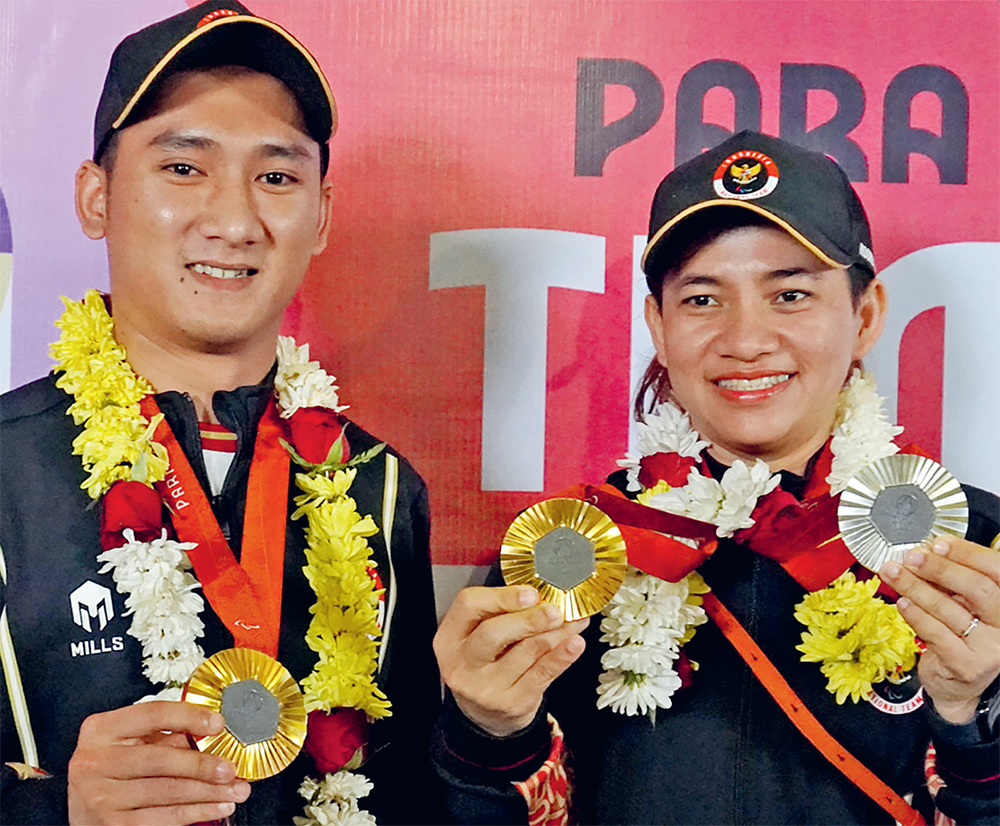 PASANGAN BARU: Leani Ratri Oktila (kanan) bersama Hikmat Ramdani yang menyabet emas pada nomor ganda campuran klasifikasi SL-3-SU5 di Paralimpiade Paris 2024. (RIZKY AHMAD FAUZI/JAWA POS) - Image