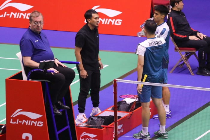 Mohammad Ahsan (hitam) saat memberikan arahan kepada Sabar Karyaman Gutama/Moh Reza Pahlevi Isfahani saat bertanding di perempat final Hongkong Open 2024. (Dok: PBSI) - Image