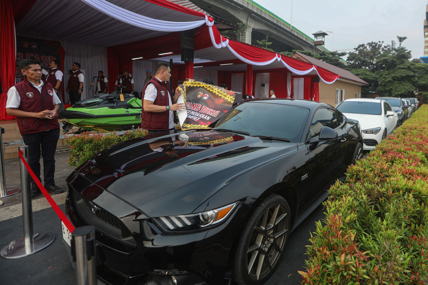 Petugas melihat barang bukti tindak pidana pencucian uang (TPPU) dari kejahatan narkoba, di Lapangan Bhayangkara Mabes Polri, Jakarta, Rabu (18/9/2024). (Salman Toyibi/Jawa Pos) - Image